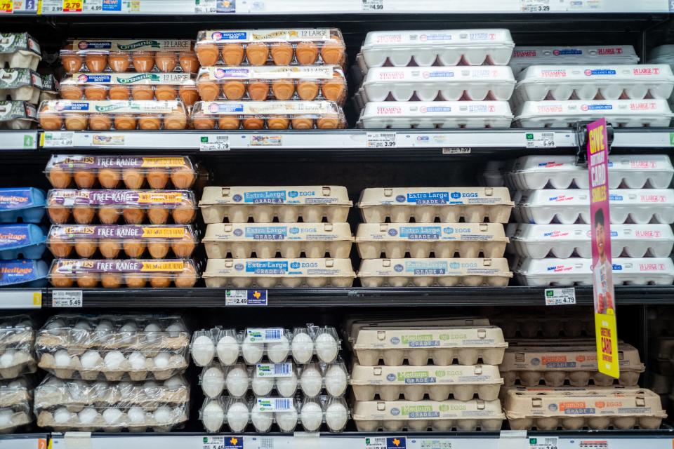 Cartons of eggs stacked on a grocery store shelf.