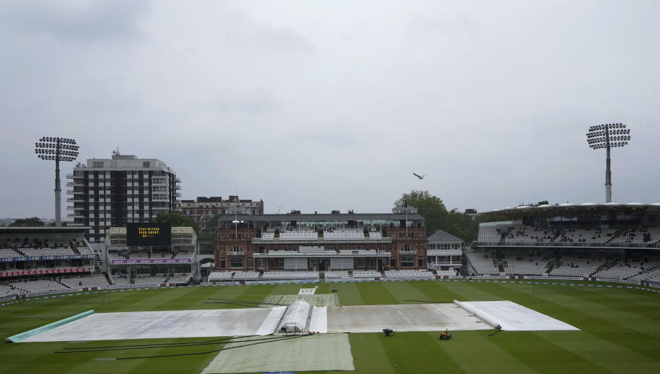 Rain covers protect the pitch, as rain delays the start of play on the third day of the Test match between England and New Zealand at Lord's cricket ground in London, Friday, June 4, 2021. (AP Photo/Kirsty Wigglesworth)