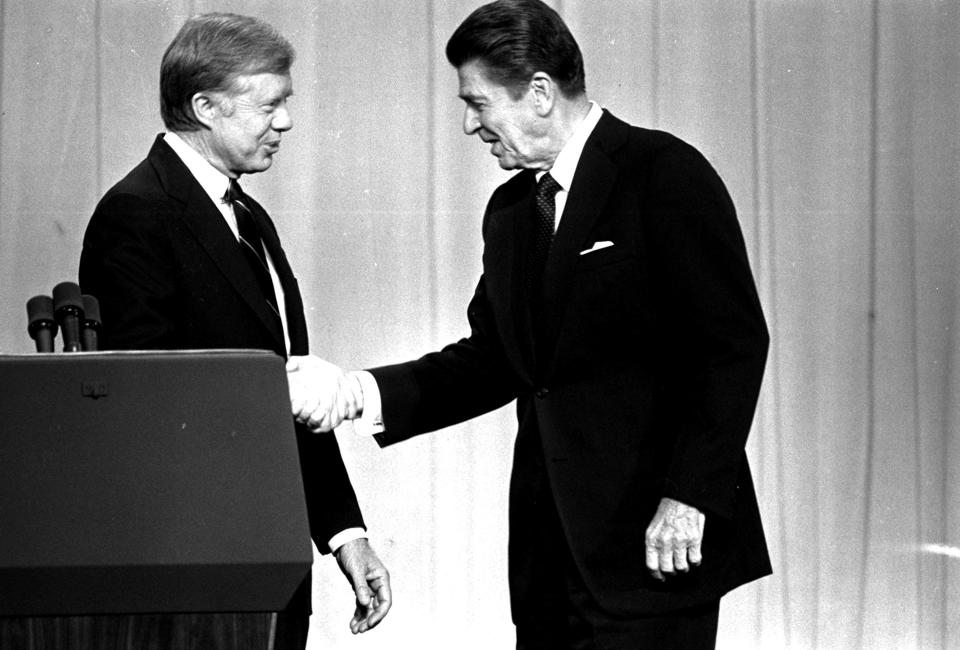 Jimmy Carter and Ronald Reagan shake hands on Oct. 28, 1980, in Cleveland before their debate.