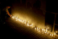 <p>A man places a candle during a vigil outside the Polytechnic School in Rosario, Argentina, Wednesday, Nov. 1, 2017. Five victims killed in the bike path attack near the World Trade Center in New York were part of a group of friends celebrating the 30th anniversary of their graduation from the Polytechnic School of Rosario, Argentina. (Photo: Natacha Pisarenko/AP) </p>