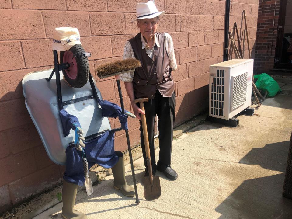 Mr Don Bradshaw, 94, with his "wheelbarrow man" creation in the gardens of FACT, a community hub in March, Cambridgeshire