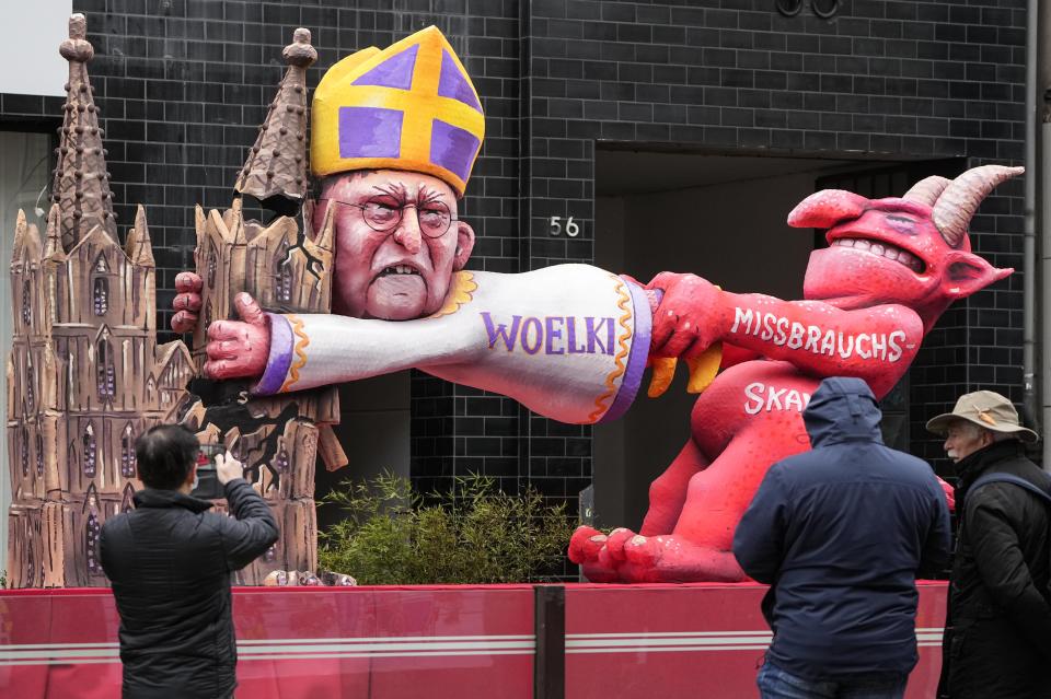 A carnival float depicting German Cardinal Rainer Maria Woelki fighting with an abuse devil is seen ahead of the start of the traditional carnival parade in Duesseldorf, Germany, on Monday, Feb. 20, 2023. The foolish street spectacles in the carnival centers of Duesseldorf, Mainz and Cologne, watched by hundreds of thousands of people, are the highlights in Germany's carnival season on Rosemonday. (AP Photo/Martin Meissner)