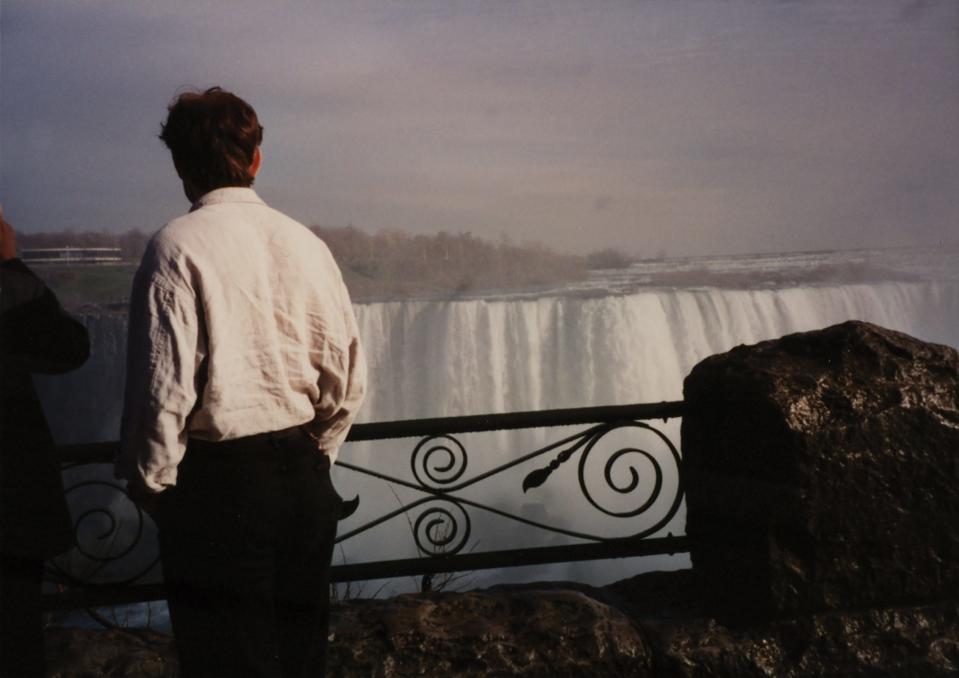 Elon Musk standing in front of waterwalls.