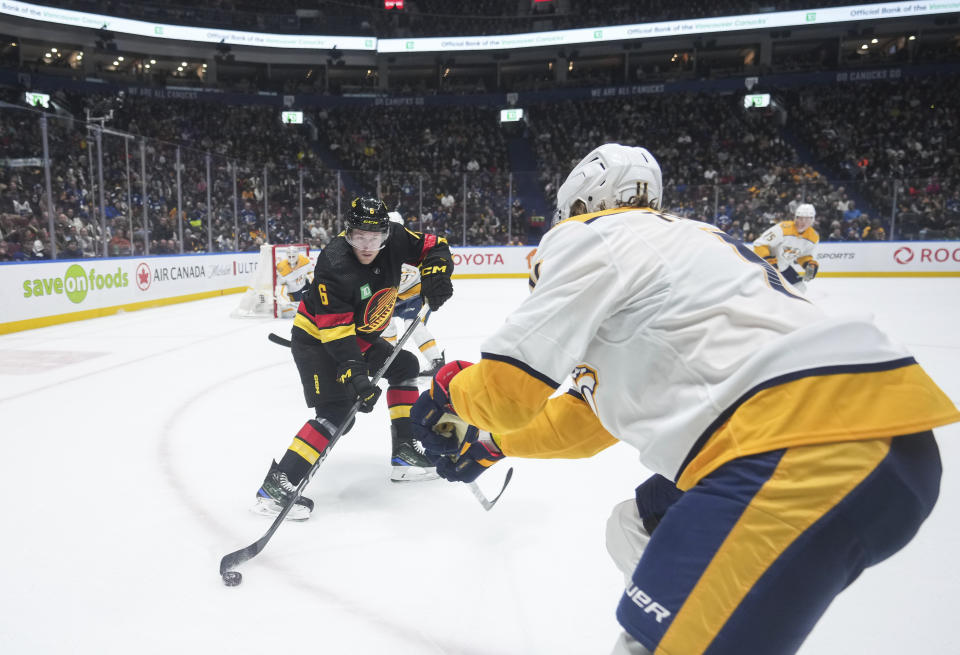 Vancouver Canucks' Brock Boeser, left, and Nashville Predators' Samuel Fagemo vie for the puck during the first period of an NHL hockey game Tuesday, Oct. 31, 2023, in Vancouver, British Columbia. (Darryl Dyck/The Canadian Press via AP)