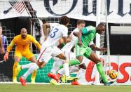 United States midfielder Jermaine Jones (13) defends Nigeria forward Shola Ameobi (23) during the first half at EverBank Field. Mandatory Credit: Kim Klement-USA TODAY Sports