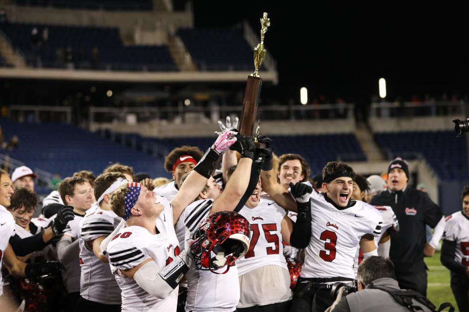 Chardon players and staff embrace and celebrate after winning the OHSAA Division III State Final game between the Badin Rams and The Chardon Hilltoppers at Tom Benson Hall of Fame Stadium on Friday Dec. 3, 2021. Chardon won the game with a final score of 21-14.