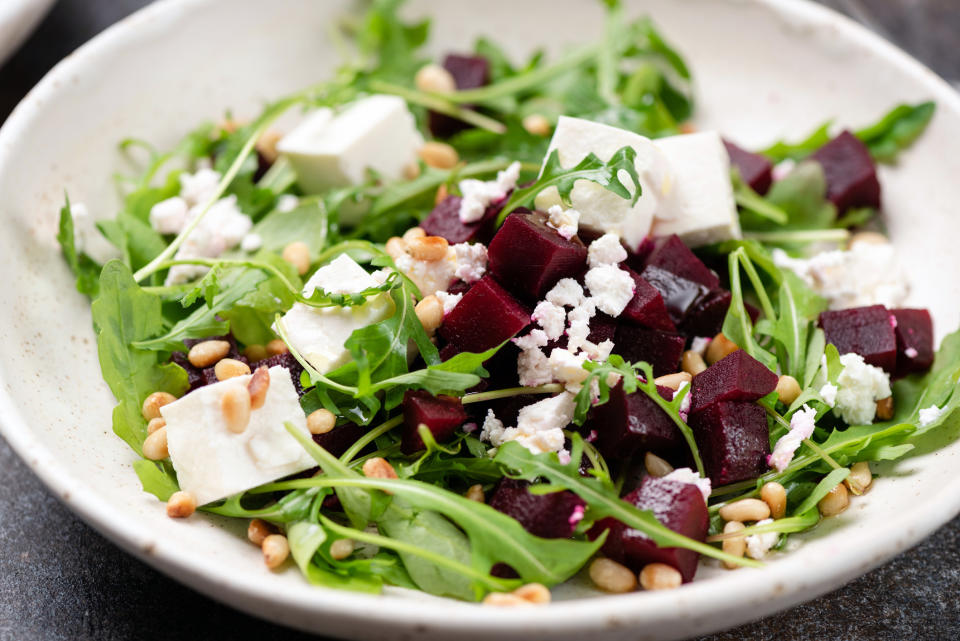 Arugula salad with nuts, beets, feta cheese, and tofu