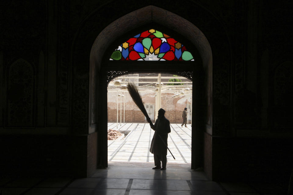 A volunteer cleans the main gate of a mosque ahead of the upcoming Muslim fasting month of Ramadan, in Peshawar, Pakistan, Saturday, April 2, 2022. The Muslim holy month of Ramadan — when the faithful fast from dawn to dusk — began at sunrise Saturday in much of the Middle East, where Russia's invasion of Ukraine has sent energy and food prices soaring. (AP Photo/Muhammad Sajjad)