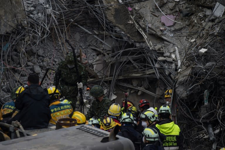 A rescue worker speaks to his colleagues after a probe for finding signs of life was placed into a gap on what was the top of the Wei-Kuan complex that collapsed in the 6.4 magnitude earthquake, in Tainan on February 10, 2016