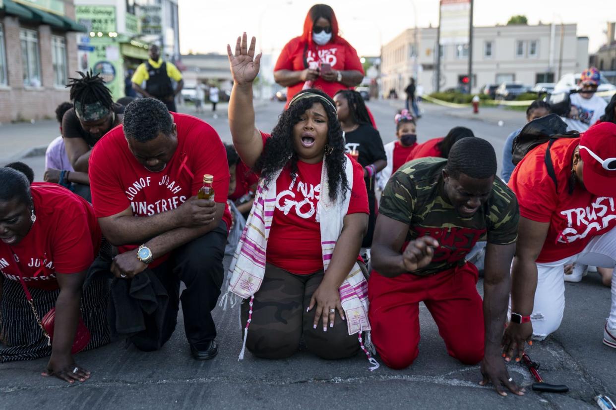 <span class="caption">People pray at the scene of the mass shooting in Buffalo, N.Y., on May 15, 2022.</span> <span class="attribution"><a class="link " href="https://media.gettyimages.com/photos/people-pray-at-the-scene-of-a-mass-shooting-at-tops-friendly-market-picture-id1240708947?s=2048x2048" rel="nofollow noopener" target="_blank" data-ylk="slk:Kent Nishimura/Los Angeles Times via Getty Images;elm:context_link;itc:0;sec:content-canvas">Kent Nishimura/Los Angeles Times via Getty Images </a></span>
