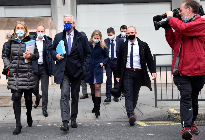 A member of the media points his camera at European Union's chief Brexit negotiator Michel Barnier wearing a face mask as he walks to Brexit trade negotiations in London