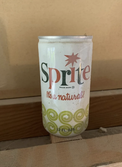 Vintage Sprite can with slogan "It's a natural!" on a wooden surface