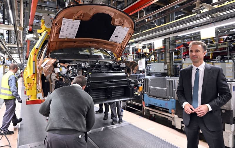 Florian Huettl, Managing Director of Opel Automobile GmbH, stands next to an Opel Grandland electric on the assembly line at Opel Eisenach GmbH. Martin Schutt/dpa