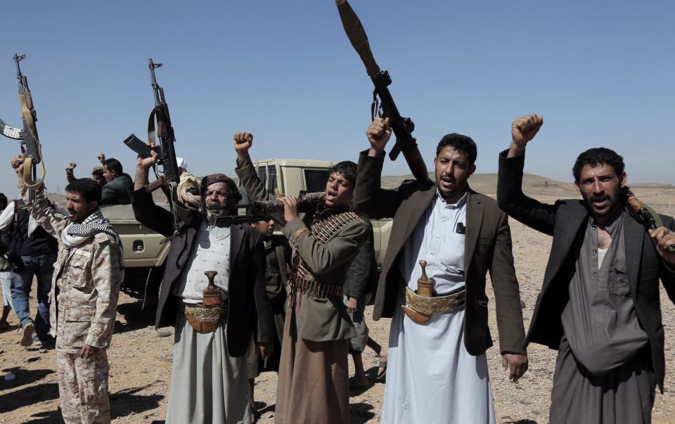 Yemen's Houthi followers lift their rifles and shout slogans