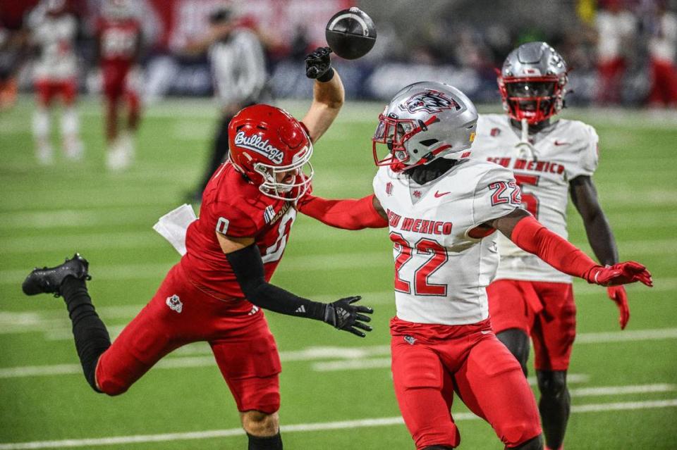 New Mexico defensive back Christian Ellis (22) breaks up a pass intended for Fresno State wideout Mac Dalena (0) in the Lobos’ 25-17 victory over the Bulldogs Saturday, Nov. 18, 2023. Ellis was called for pass interference on the play.