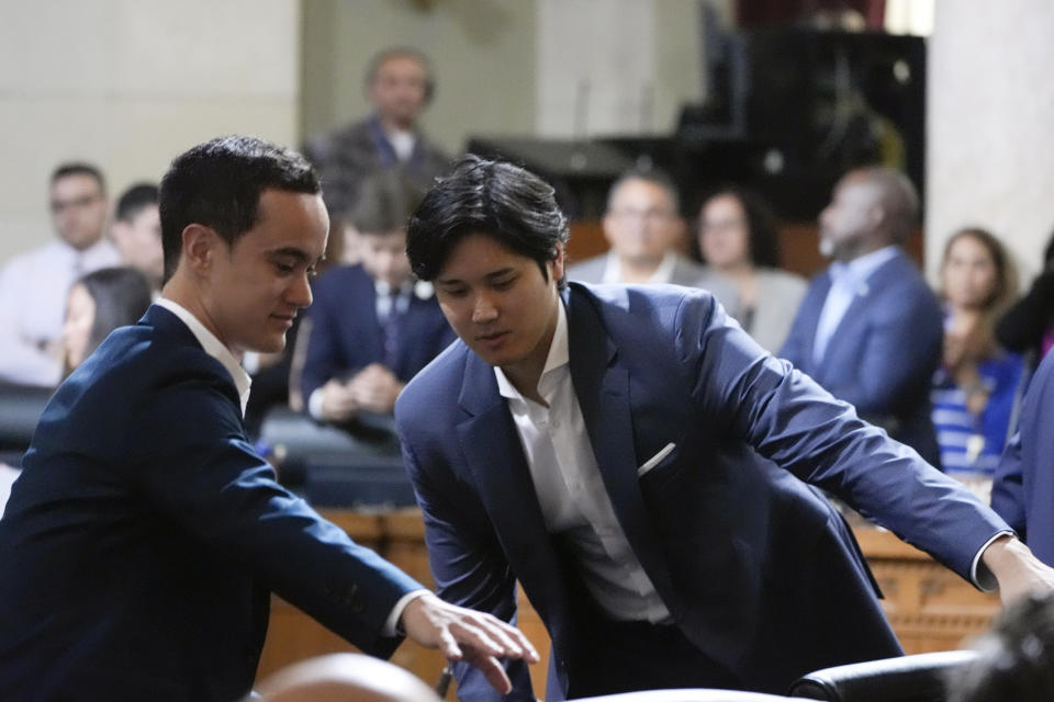 Los Angeles Dodgers baseball star Shohei Ohtani, right, prepares to leave after being honored Friday, May 17, 2024, during a council meeting in Los Angeles. (AP Photo/Damian Dovarganes)