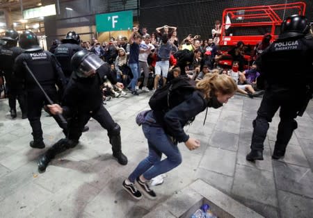 Protesters clash with police officers as they demonstrate at the airport, after a verdict in a trial over a banned independence referendum, in Barcelona