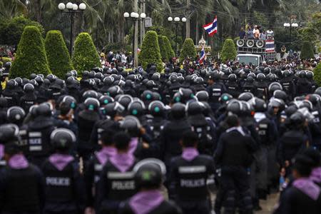 Thai riot police stand guard as anti-government protesters rally inside a compound of the Thai Royal Police Club in Bangkok February 21, 2014. REUTERS/Athit Perawongmetha