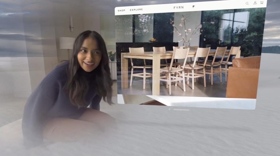 A first-person perspective of using Apple Vision Pro, with a person using passthrough to see their apps as well as a person standing in front of them.