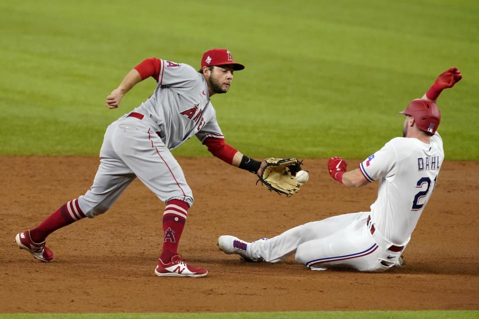 El segunda base David Fletcher, izquierda, de los Angelinos de Los Ángeles, intenta quedarse con la pelota tras un lanzamiento del receptor Max Stassi antes de poner fuera a David Dahl, derecha, de los Rangers de Texas, en un intento de robo de base en el tercer inning del partido en Arlington, Texas, el miércoles 28 de abril de 2021. (AP Foto/Tony Gutierrez)