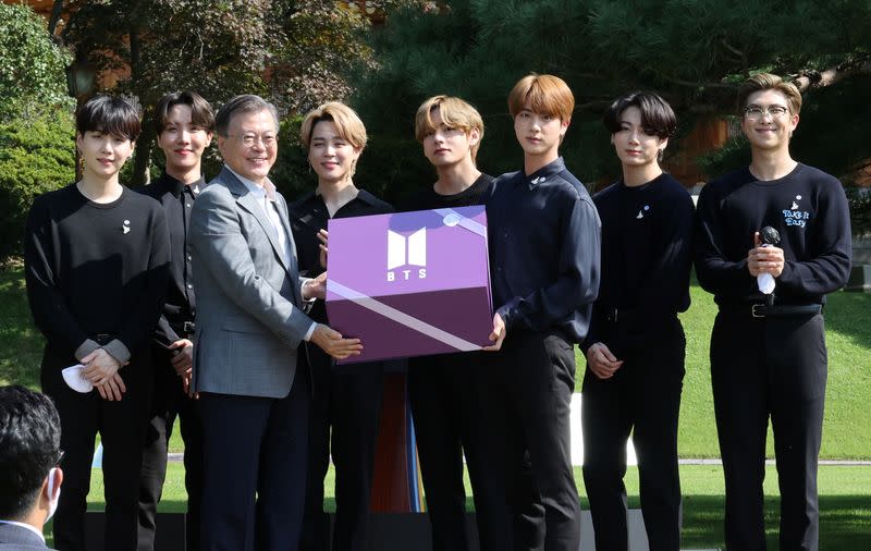 South Korean President Moon Jae-in and members of K-Pop boyband BTS pose for photographs with a gift given by BTS during Youth Day at the Presidential Blue House in Seoul