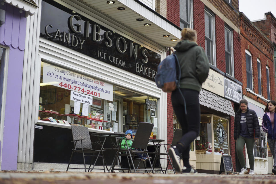 FILE - In this Nov. 22, 2017 file photo, pedestrians pass the storefront of Gibson's Bakery in Oberlin, Ohio. The 9th District Court of Appeals upheld a $31 million judgment on Thursday, March 31,, 2022 against Oberlin College that had been awarded to Gibson's Bakery and Food Mart that successfully claimed it was libeled by the school after a shoplifting incident in November of 2016. The court rejected all of the college's appeal arguments. Oberlin students and staff staged protests outside the market after the shoplifting incident . A jury in June 2019 awarded story owners $44 million in compensatory and punitive damages and $6 million in attorney fees. The Gibsons' award was later reduced by a judge to $25 million. (AP Photo/Dake Kang, File)