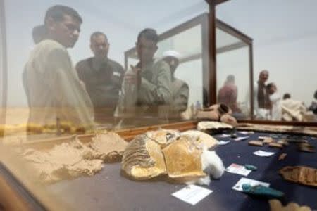 A crowd gathers to look at a glass case displaying objects that were found inside a burial site in Minya, Egypt May 13, 2017. REUTERS/Mohamed Abd El Ghany