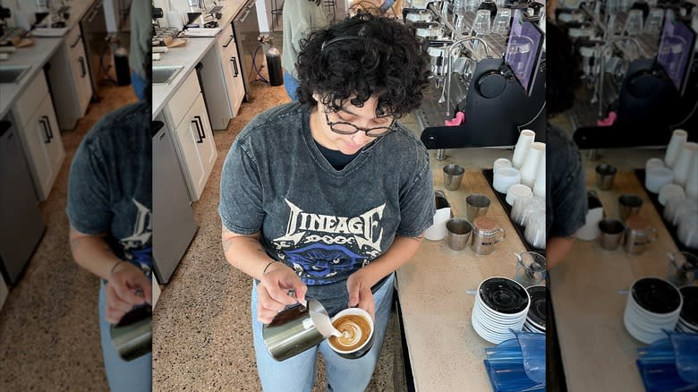 Barista pouring milk in coffee