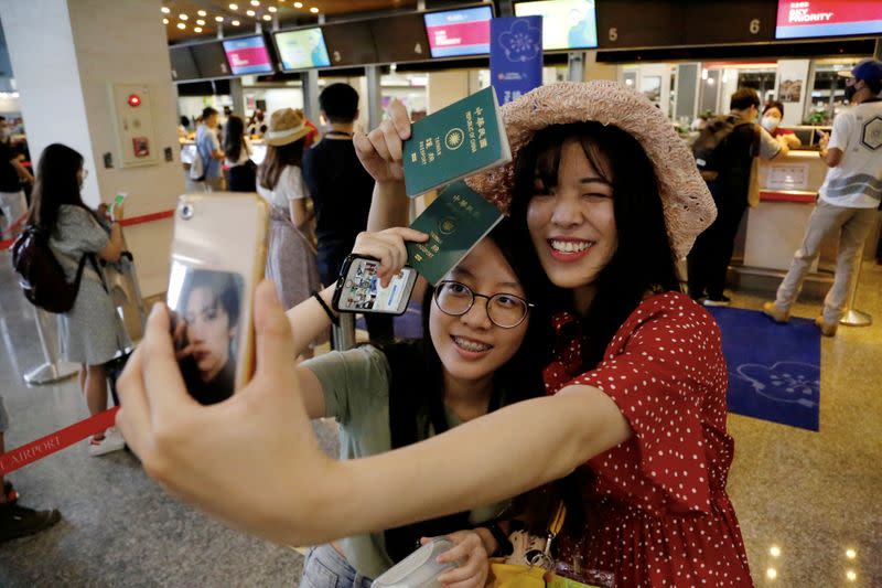 People who want to leave the island, but cannot due to coronavirus disease-related (COVID-19) travel restrictions, take selfies during the "fake" travel experience for tourists simulating the experience of using an international airport at Songshan airpor