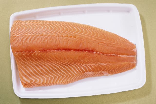 Fresh farmed atlantic salmon on styrofoam supermarket tray