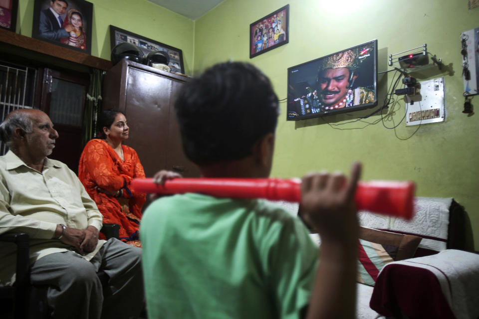 An Indian family watches epic television series “Ramayan” at their home in Jammu, India May 18, 2020. The country’s public broadcaster last month revived the wildly popular series from the 80s and brought back to life for a captive audience under lockdown. Staying home under a lockdown as they wait for the worst of the coronavirus pandemic to pass, millions of Indians are turning to their Gods. Not in their prayer rooms, but on their televisions. (AP Photo/Channi Anand)