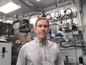 Greg Barranger, newly appointed Vice President of AmmPower’s IAMM Division standing inside the company’s demonstration, green ammonia synthesis machine.