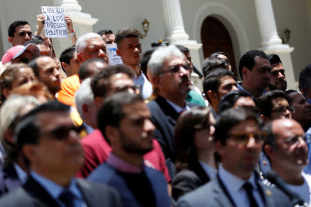 A woman holds a placard that reads "Release the political prisoners", as Freddy Guevara, First Vice President of the National Assembly and deputy of the opposition party Popular Will (Voluntad Popular), attends a news conference in Caracas, Venezuela April 2, 2017. REUTERS/Carlos Garcia Rawlins