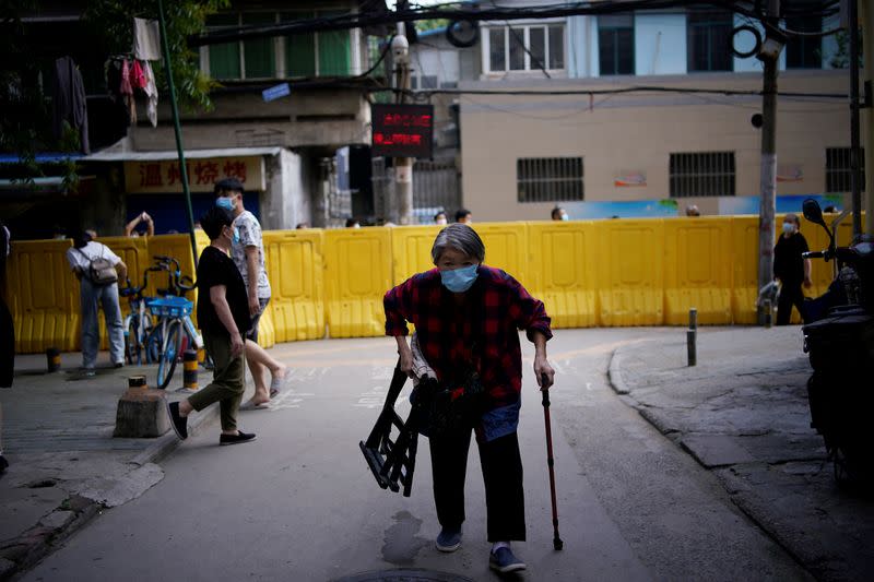 A resident wearing a face mask walks after receiving a nucleic acid test at a residential compound in Wuhan