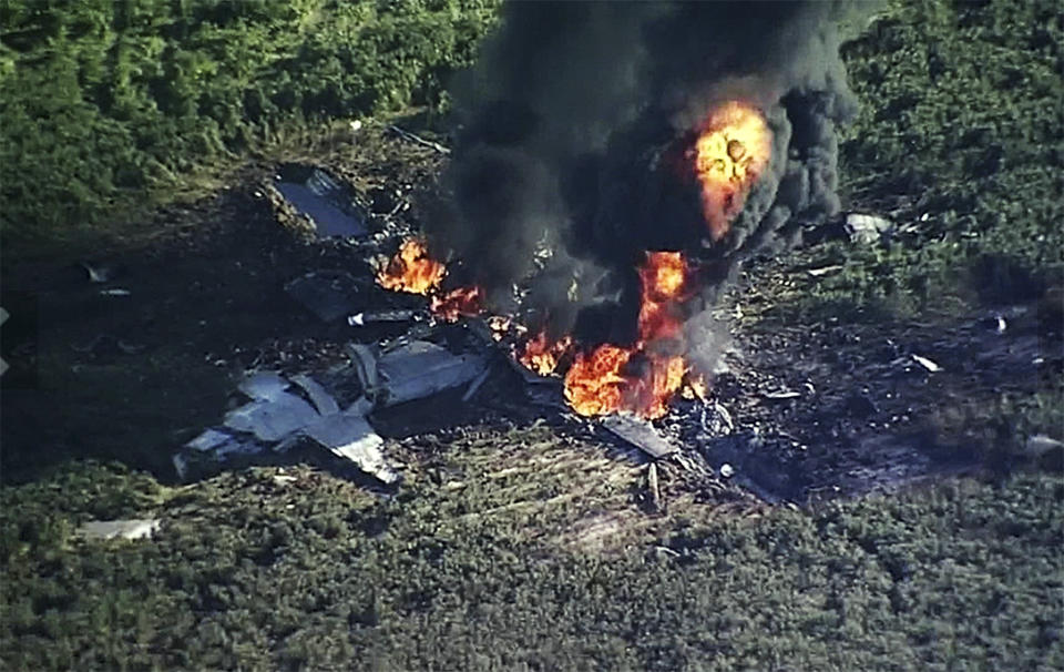 FILE - In this July 10, 2017, file image made from video provided by WLBT-TV, smoke and flames rise from a military plane that crashed in a farm field in Itta Bena, Miss. Investigators say bad maintenance practices at a Georgia air force base missed a deteriorating propeller blade that broke off six years later as a U.S. Marine Corps transport plane cruised over Mississippi at 20,000 feet, causing the KC-130T to break into pieces and plunge into a soybean field, killing 15 Marines and a Navy corpsman, according to the report on the causes of the July 10, 2017, crash, released Wednesday, Dec. 5, 2018. (WLBT-TV via AP, File)