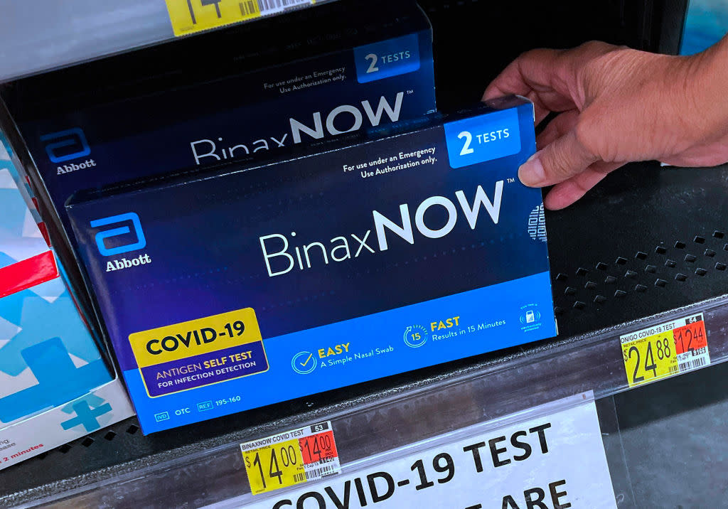 At-home COVID-19 test kits on a shelf at a Walmart in Orlando, Fla.