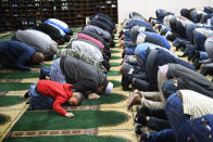 FILE - In this Feb. 3, 2017, file photo, Aaqib Rahman, lower left, prays with his father Muhammad Rahman at the Islamic Center of Southern California in Los Angeles. The California Department of Public Health released a framework under which county health departments can approve the reopening of churches, mosques, synagogues and other houses of worship that have mostly shuttered their doors since Gov. Gavin Newsom's March stay-at-home order designed to slow the spread of the coronavirus.California churches can resume in-person services but worshippers will be limited to 100 people and they should wear masks, avoid sharing prayer books and skip the collection plate under state guidelines released Monday, May 25. (AP Photo/Mark J. Terrill, File)