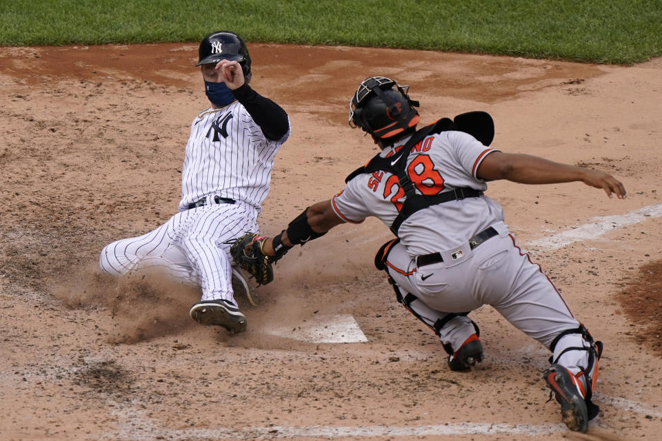 New York Yankees' Clint Frazier, left, is safe scoring ahead of a tag by Baltimore Orioles catcher Pedro Severino (28) on pinch hitter Gleyber Torres's two-run double during the eighth inning of a baseball game, Sunday, Sept. 13, 2020, at Yankee Stadium in New York. (AP Photo/Kathy Willens)