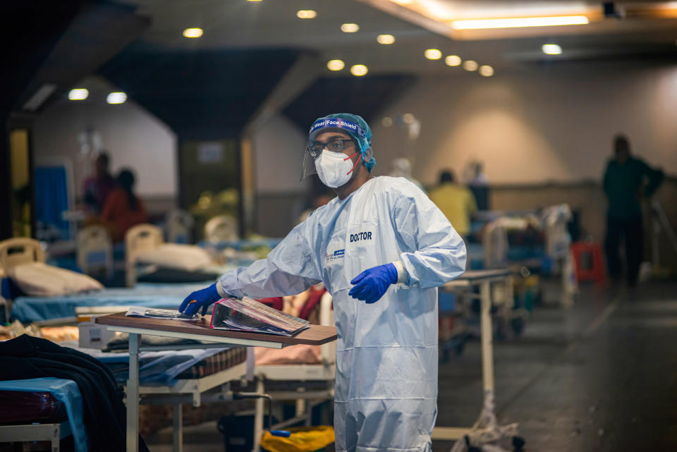 A doctor wearing a Personal Protective Equipment suite (PPE) working inside of the Covid-19 Care Centre set up at Shehnai Banquet Hall attached to Lok Nayak covid-19 Hospital. Young doctors wearing Personal Protective Equipment suites (PPE) working inside the covid-19 care centre belongs to NGO 