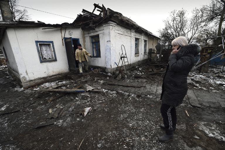 A woman stands next to her shelled house in the eastern Ukrainian city of Donetsk , on December 9, 2014