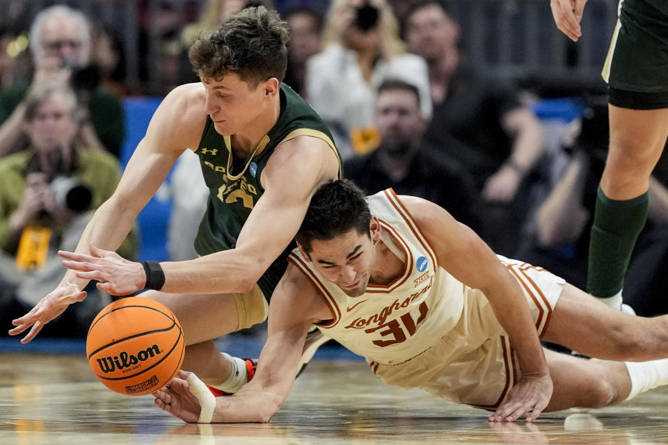 Colorado State forward Patrick Cartier (12) and Texas forward Brock Cunningham (30) chase a loose ball during the first half of a first-round college basketball game in that NCAA Tournament, Thursday, March 21, 2024, in Charlotte, N.C. (AP Photo/Mike Stewart)
