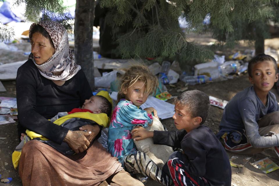 A displaced family from the minority Yazidi sect, fleeing the violence in the Iraqi town of Sinjar, waits for food while resting at the Iraqi-Syrian border crossing in Fishkhabour, Dohuk province August 13, 2014. REUTERS/Youssef Boudlal (IRAQ - Tags: CIVIL UNREST POLITICS CONFLICT SOCIETY )