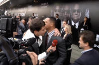 In this video image taken from AP video U.S. actor Will Smith, center right, is embraced by reporter Vitalii Sediuk, white suit, from the Ukrainian television channel 1+1 on the red carpet before the premiere of "Men in Black III" Friday May 18, 2012 in Moscow. Hollywood star Will Smith has slapped a male television reporter who tried to kiss him before the Moscow premiere of "Men in Black III." Smith pushed him away and then slapped him lightly across the cheek with the back of his left hand. (AP Photo via AP video)