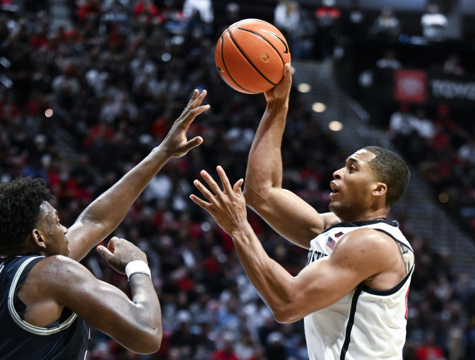 San Diego State forward Jaedon LeDee (13) shoots over Utah State forward Great Osobor (1) during the second half of an NCAA college basketball game Saturday, Feb. 3, 2024, in San Diego. (AP Photo/Denis Poroy)