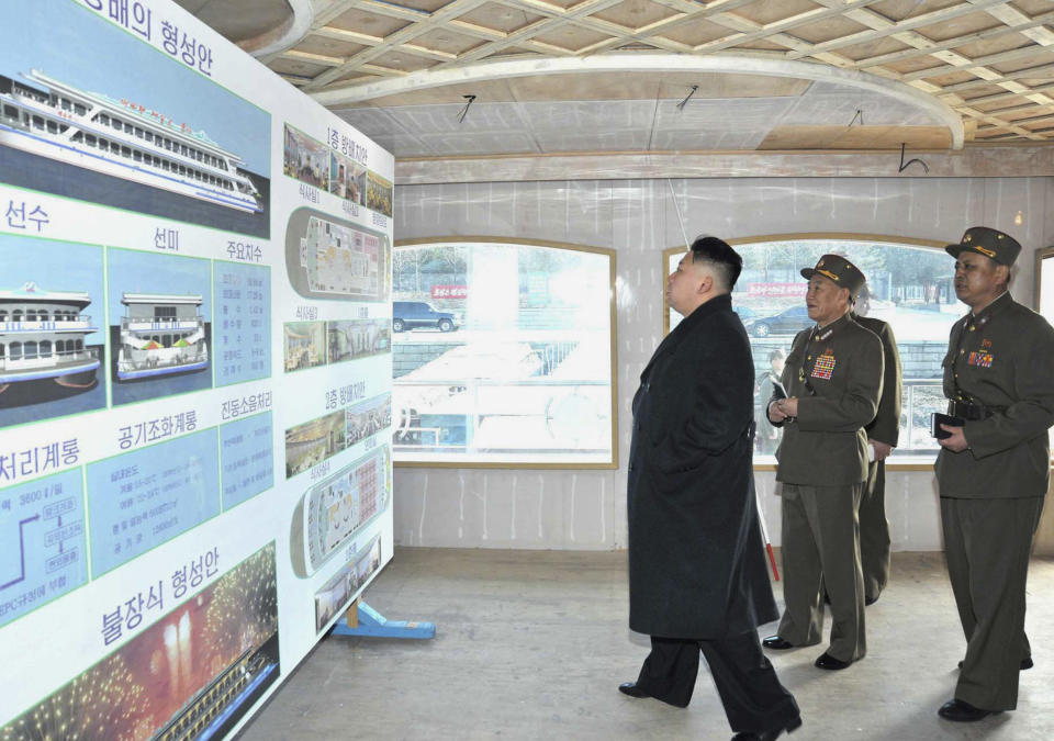 This undated photo released on March 25, 2013, North Korean leader Kim Jong-Un (C) inspecting of a restaurant boat Taedonggang being laid down by the Korean People's Army at an undisclosed location in North Korea.