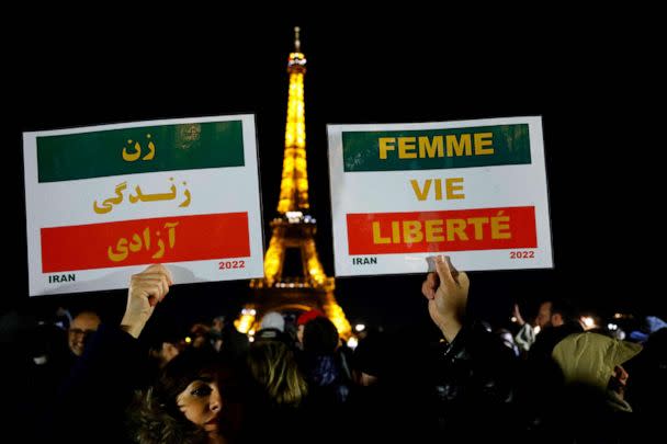 PHOTO: Protesters hold placards with the slogan 'Woman. Life. Freedom.' during a gathering on the Trocadero Esplanade to attend the slogan's display on the Eiffel Tower, in Paris, on Jan. 16, 2023. (Ludovic Marin/AFP via Getty Images)