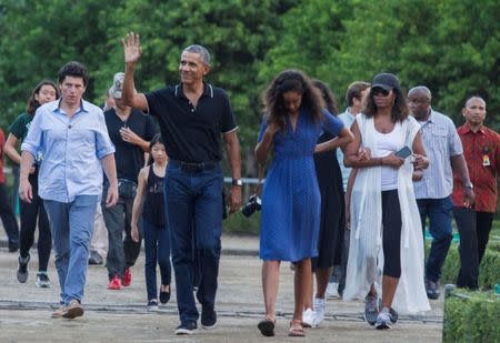 Former U.S. President Barack Obama waves while walking with his daughter Mali and his wife Michelle during a visit to the 9th-century Borobudur Temple in Magelang, Indonesia June 28, 2017. REUTERS/Pius Erlangga