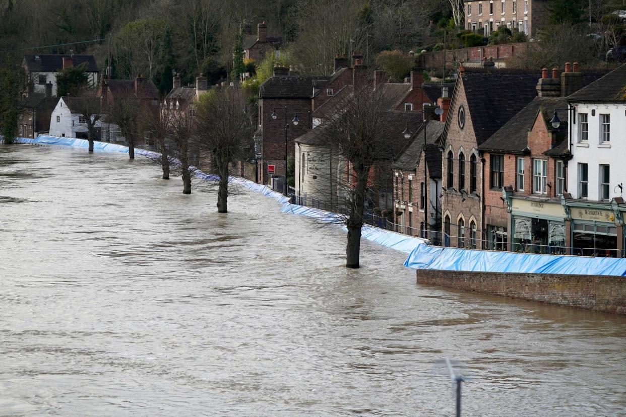 Buildings are seen behind temporary flood barriers that are overwhelmed by water: Getty Images