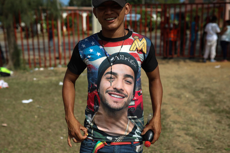 <p>A Central American migrant shows off his shirt featuring Colombian singer Maluma during the annual Migrant Stations of the Cross caravan or “Via crucis,” organized by the “Pueblo Sin Fronteras” activist group, at a sports center during the group’s few-days stop in Matias Romero, Oaxaca state, Mexico, Monday, April 2, 2018. The “Stations of the Cross” migrant caravans have been held in southern Mexico for about 10 years, beginning as short processions of migrants, some dressed in biblical garb and carrying crosses, as an Easter-season protest against the kidnappings, extortion, beatings and killings suffered by many Central American migrants as they cross Mexico. (Photo: Felix Marquez/AP) </p>