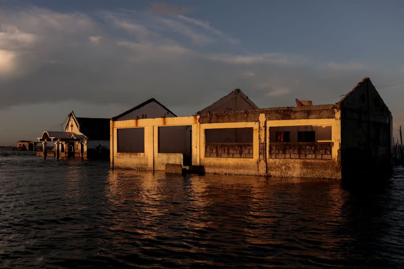 The Wider Image: Rising seas threaten early end for sinking village in Philippines